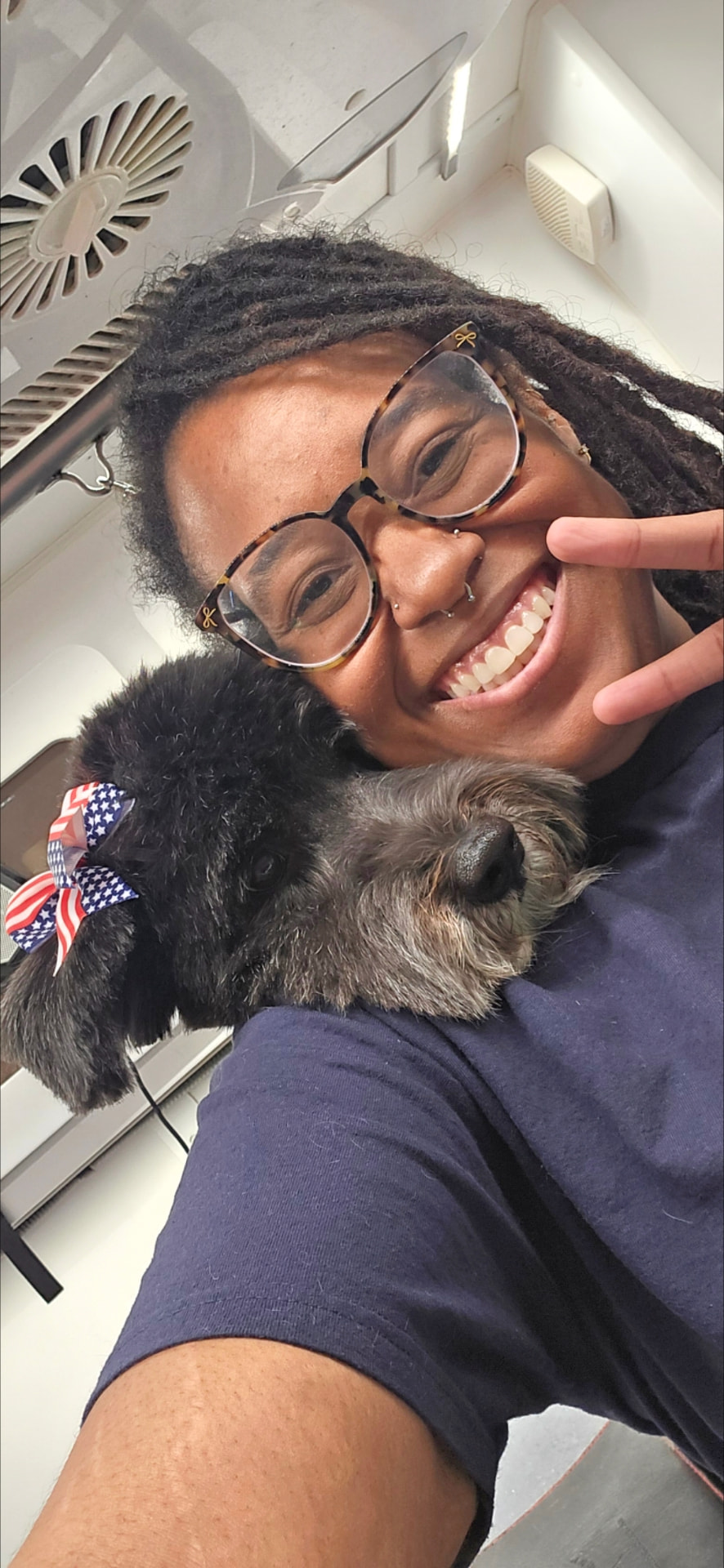 Brittany with a black dog wearing an American flag bow after a full spa day groom
